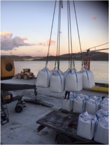 Mineral bags being loaded onto a vessel for export